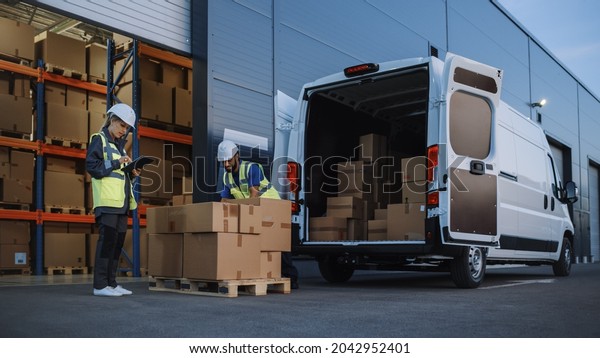 Outside of Logistics Distributions Warehouse With\
Inventory Manager Using Tablet Computer, talking to Worker Loading\
Delivery Truck with Cardboard Boxes. Online Orders, Purchases,\
E-Commerce Goods