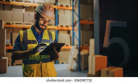 Outside Of Logistics Retail Warehouse: Handsome Latin Manager Using Tablet Computer For Inventory. Delivery Service With Cardboard Boxes, Online Orders, E-Commerce. Evening Shot