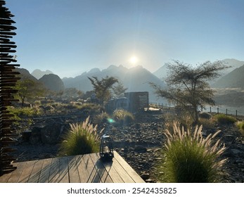 Outside a mountain cabin, sunrise in the horizon. Backdrop of several mountains near a lake - Powered by Shutterstock