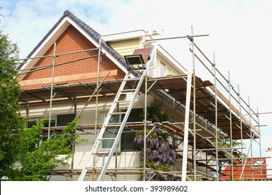 Outside renovation of modern residential house, scaffolding tower