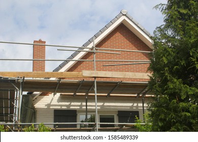 Outside Renovation And Painting Of Dutch House With Shutter Doors And Scaffold Tower