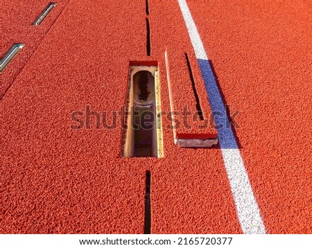 Outside running track slot drain along radius, adjacent to steeplechase, with cleanout.	
