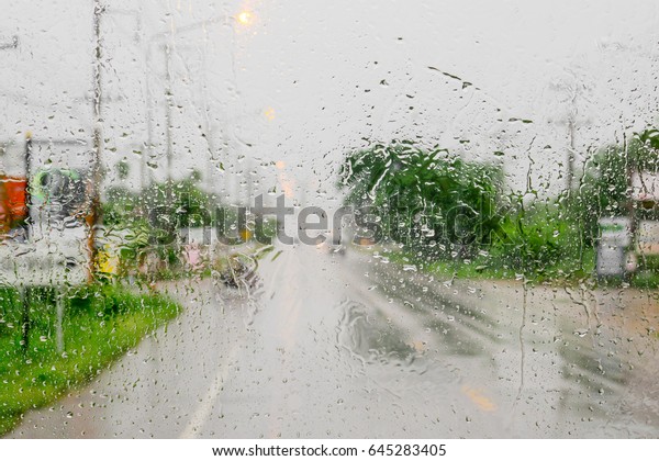 The outside view by\
looking from the inside of car to see the blur view at the outside\
by the rain drop. 