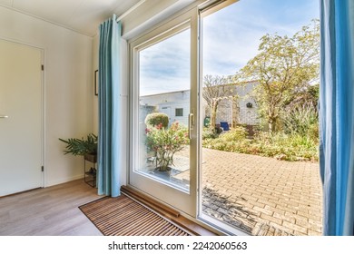 an outside view from the inside of a room with sliding glass doors and blue drapes hanging on the wall