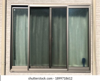 Outside view of modern house glass slide panel window on wall.