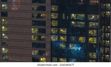 Outside View Of Panoramic Windows In Apartments Of A High Class Building At Night Timelapse. Glowing Lights In Skyscraper