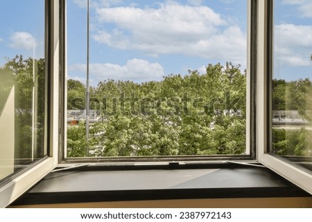 an outside view from a window with white clouds in the sky and green trees on the other side of the window