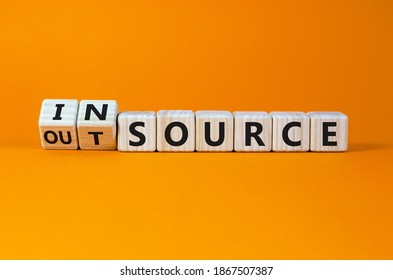 Outsource or insource symbol. Fliped wooden cubes and changed the word 'outsource' to 'insource'. Beautiful orange background, copy space. Business and outsource or insource concept.