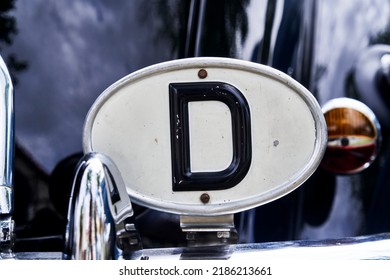 Oval Badge Made Of White Sheet Metal With Black Letter D To Mark The Country Of Origin Germany On A Car