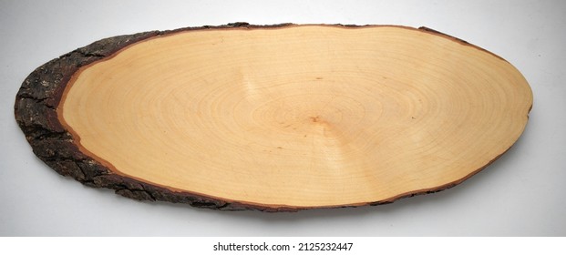 An oval cut of a tree on a white isolate, a clean place for the inscription.Age-old rings on a tree. Woodworking.