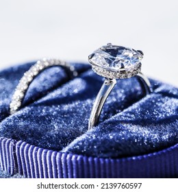 Oval Diamond Engagement Ring In Blue Velvet Ring Box On White Background