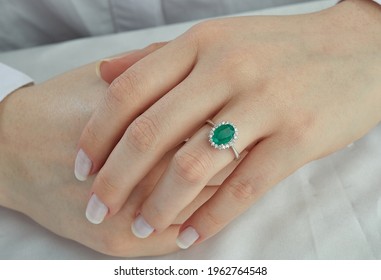 Oval emerald diamond ring on lady finger - Shutterstock ID 1962764548