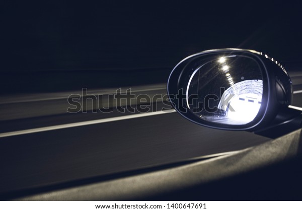 Oval mirror car reflecting highway driving inside\
a tunnel