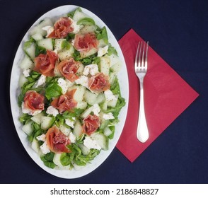 Oval Plate With Lettuce, Melon, Mozzarella And Jamon Salad. A Beautifully Served Dish. View From Above.