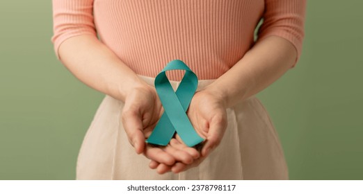 Ovarian and Cervical Cancer Awareness. Woman Holding Teal Ribbon on Lower Abdomen, Uterus, Female Reproductive System, Women's Health, PCOS and Gynecology  - Powered by Shutterstock