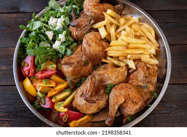 Oven Baked Half Chicken With Salad And Homemade French Fries. Healthy Family Meal Served On A Large Platter Isolated On Wooden Background