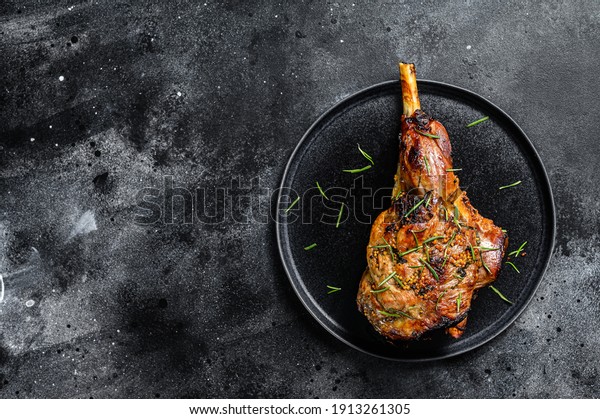 Oven baked lamb leg. Dark background. Top view.\
Copy space