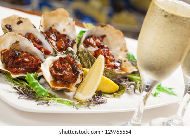 Oven baked oysters kilpatrick with glasses of champagne