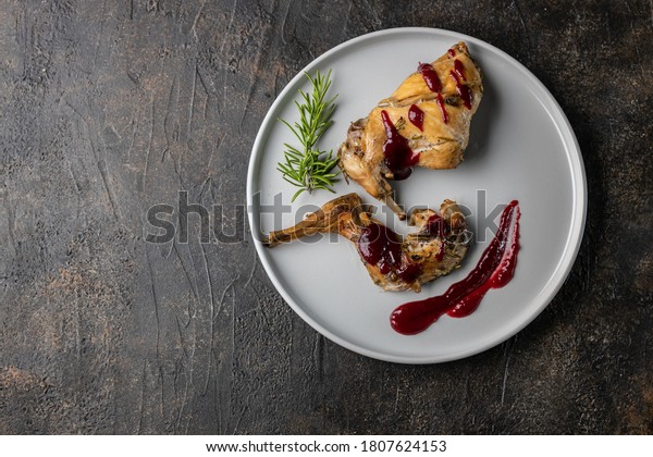 Oven Baked rabbit legs with cranberry sauce and\
rosemary. Rabbit confit