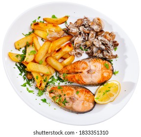 Oven Baked Salmon Steaks Served With Fried Potato, Mushrooms And Lemon. Isolated Over White Background