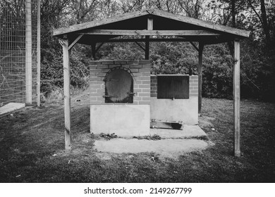 An Oven For Baking Bread Stands Outside Under A Wooden Roof