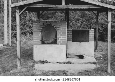 An Oven For Baking Bread Stands Outside Under A Wooden Roof