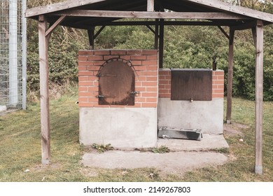 An Oven For Baking Bread Stands Outside Under A Wooden Roof