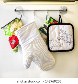 Oven Gloves Hanging In A Row On The Kitchen Frige