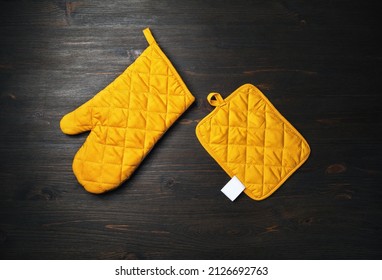 Oven mitt and potholder on wooden background. Kitchen accessory. Cooking mitten, oven-glove. Flat lay.