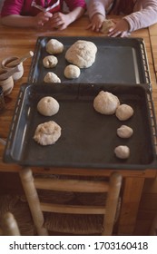 Oven trays with bread dough made by children.