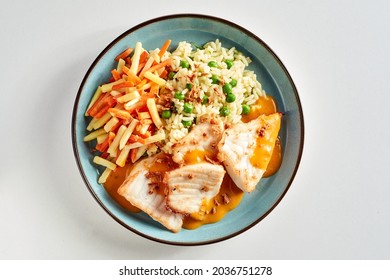 Oven-baked Fillets Of Cichlid Fish Served With Mixed Vegetables And Drizzled With A Savory Sauce In A Top Down View On A Plate Over White Fro Menu Advertising