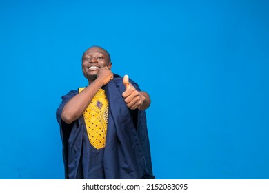 over excited black millennial guy wears African attire gives a thumbs up signs - Shutterstock ID 2152083095