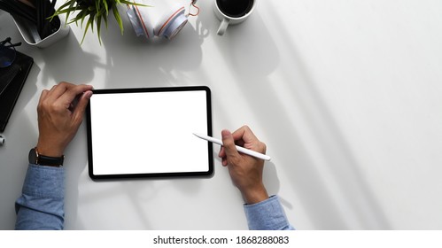 Over head shot of a graphic designer with stylus pen writing on graphic tablet with blank screen. - Powered by Shutterstock