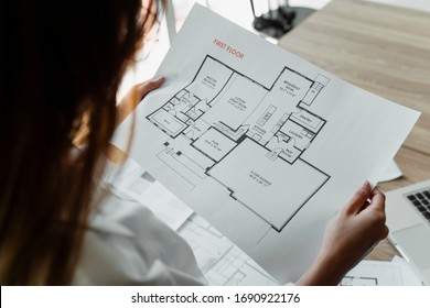 Over shoulder shot blueprint in woman's hands while she hold   look at it 