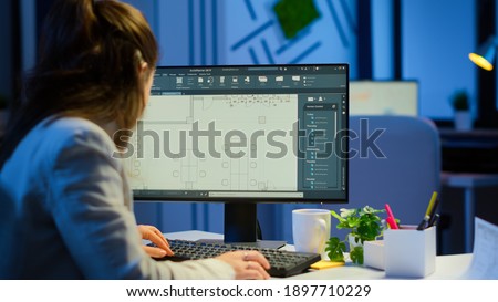 Over the shoulder shot of engineer working with architectural plans, cad software on desktop computer. Designer using arhitecture blueprints of buildings working overtime, creating and studying Imagine de stoc © 