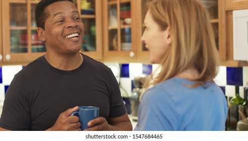 Over The Shoulder Shot Of Happy Black Man Talking To His Wife While They Drink Morning Coffee In The Kitchen. Senior Couple Talking About Their Day