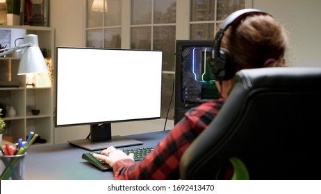 Over Shoulder Shot Of Pro Female Gamer Playing On Computer With Green Mock-up Screen.