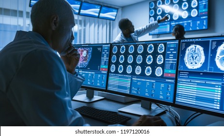 Over the Shoulder Shot of Senior Medical Scientist Working with CT Brain Scan Images on a Personal Computer in Laboratory. Neurologists in Research Center Work on Brain Tumor Cure. - Powered by Shutterstock