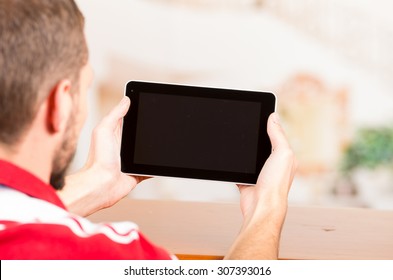 Over The Shoulder Shot Of Young Man Holding Tablet