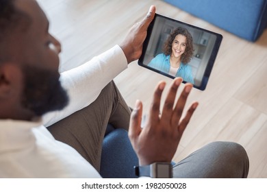 Over Shoulder View Of African American Man Making Videocall With A Young Latin Smiling Woman. Close Up Of Male Videoconferencing To Friend, Girlfriend, Greeting Colleague With Webcam On Digital Tablet