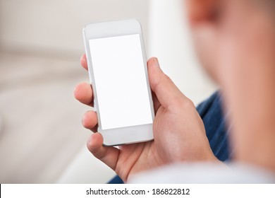 Over The Shoulder View Of The Blank Screen On A Smartphone Or Mobile Phone Held In A Mans Hand