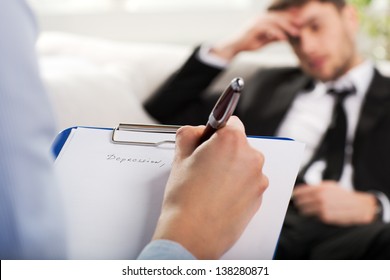 Over The Shoulder View, Of A Business Man Sit On A Couch Talking To His Psychiatrist