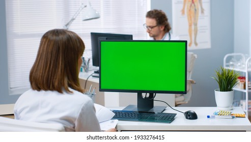 Over shoulder view of Caucasian female physician sitting in hospital office and looking at green screen on computer. Medical consultation, Video call with doctor monitor with chroma key health concept - Powered by Shutterstock