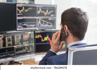 Over The Shoulder View Of Computer Screens Ful Of Charts And Data Analyses And Stock Broker Trading Online.