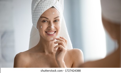 Over Shoulder View Female Face Reflected In Mirror Horizontal Banner Image, After Shower With Towel On Head 30s Woman Apply Moisturiser For Dehydrated Skin, Self-care Beauty Treatment Skincare Concept