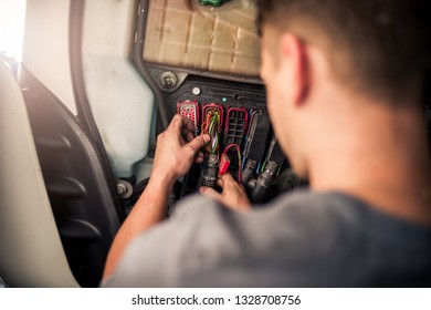 Over Shoulder View On A Man Repairing Wiring Electronics Of The Semi Truck. Diagnostics Of Broken Lorry Truck Car Repair By Service Mechanic/technician. 