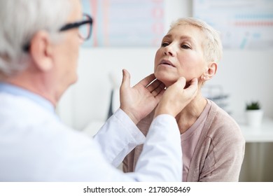 Over Shoulder View Of Qualified Cancer Doctor Touching Neck Of Mature Patient While Checking Size Of Lymph Nodes