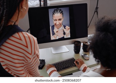 Over shoulder view at two women looking at portrait pictures on computer screen during photo selection in professional photoshoot - Powered by Shutterstock