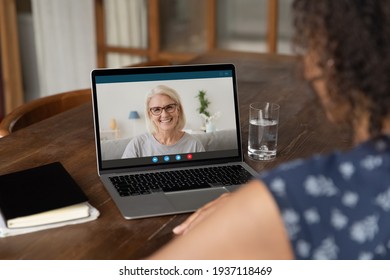 Over Shoulder View Of Young Black Woman Taking Remote Course Training Consultation Online Using Laptop. African Female Student Having Virtual Meeting By Video Call With Pleasant Old Lady Tutor Teacher