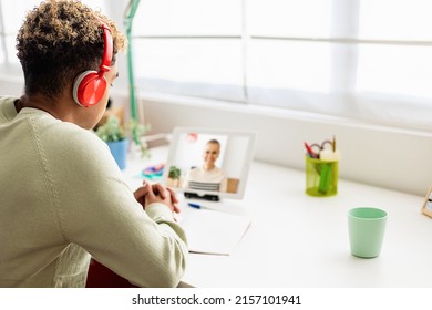 Over The Shoulder View Of Young Hispanic Latino Student Listening Female Teacher While Having Online Class